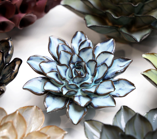 Decorative succulent plant with metallic finish on a reflective surface